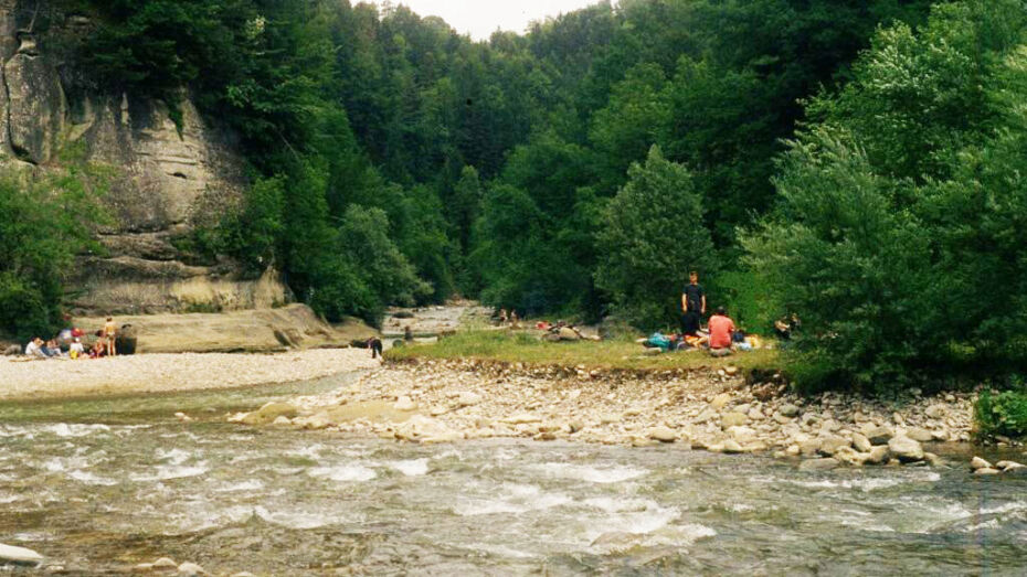 Der Fluss Sense fliesst in der Mitte des Bildes. An den Ufern rechts und links verweilen Personengruppen.